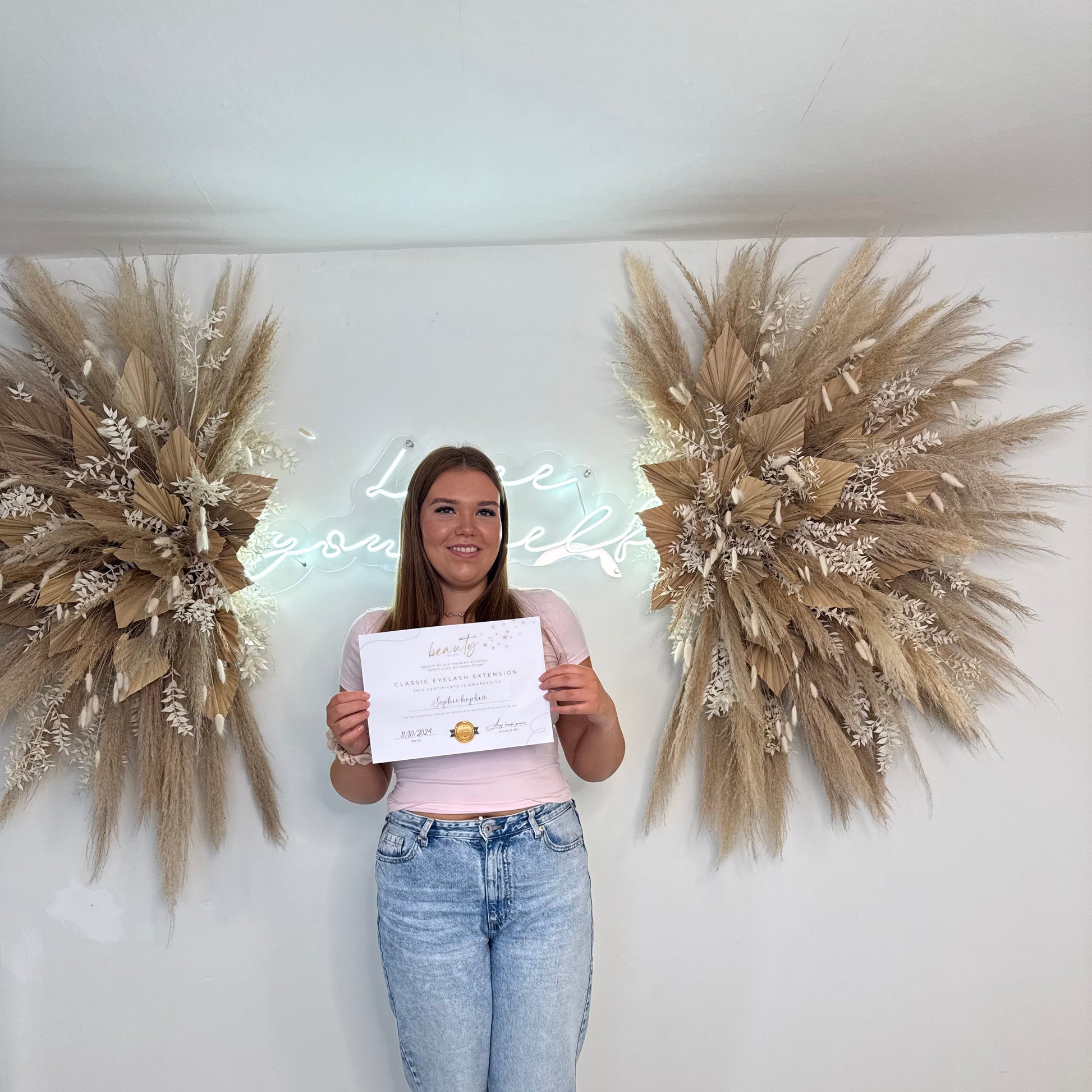 Certified lash technician holding classic lash course certificate